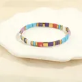 Detailed close-up of rainbow Tila bead elastic bracelet with colorful enamel finish - Rainbow