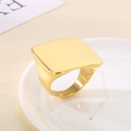 Detail of a square gold signet ring with a polished mirror finish on a ceramic tray - US 6 / Bright Gold