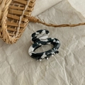 Detailed macro of black and white marble resin hair claw with France Handmade stamp - Cow Print