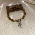 Macro shot of stone beaded bracelet with vintage silver cross pendant and floral spacers - Small / Brown