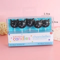 Set of 5 black cat head birthday candles in clear box packaging on pink background - Kitten Candle