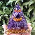 Amethyst crystal pyramid with golden lotus and foil held in hand against greenery - 8cm / Purple Ball Lotus Amethyst