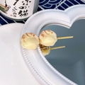 Funny realistic grilled scallop skewer hair clip with golden metal base on a mirror - Scallop Meat Skewer