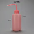 Close-up of pink 150ml plastic squeeze wash bottle with curved narrow nozzle and scale - 150ml (Pink)