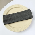 Detailed view of dark grey ribbed knit elastic headband on a ceramic display plate - Gray