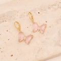 Detail of 18K gold butterfly earrings with pink resin wings and sparkling white zircon stones - Pink