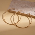 Minimalist gold round hoop earrings resting on a decorative stone with soft lighting - Silver Pin - Gold 6cm