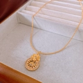 Detailopname van een gouden lotus hanger ketting met strass in een fluwelen sieradendoos - Gouden Ronde Lotus Zirkoon Stijl