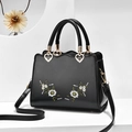 Schwarze Lederhandtasche mit weißer Blumenstickerei und goldenen Herzschnallen - Schwarz