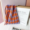 Detail of purple and orange pleated knit bag with diamond pattern on white grid fabric - Purple & Orange Argyle