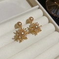 Dettaglio macro degli orecchini a fiore placcati oro 18K con perle e zirconi brillanti - Stile Fiore a Raggiera / Oro champagne