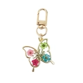 Detalle del colgante de mariposa dorada con flores secas reales de colores vibrantes - Mariposa De Flor Verde