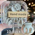 Vista de 10 mini pinzas para el cabello mate en caja con primer plano del producto - 10 Unidades/Caja / Gris claro