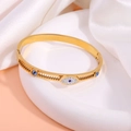 Detailed close-up of gold-plated stainless steel evil eye bangle with blue rhinestones - Evil Eye Bangle