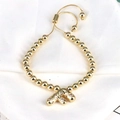 Detailed shot of golden bead bracelet with zircon-studded letter F charm and adjustable cord - Letter F