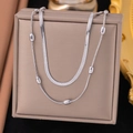 Close-up of double-layered silver snake chain necklace and beads on a jewelry gift box - Bead + Blade / Steel