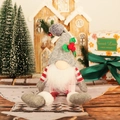 Detail of Nordic Christmas gnome with grey knitted hat, white beard, and red berry accents - Gray
