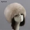 Close-up of thick apricot faux fur hat with plush texture on display stand - Apricot
