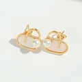 Macro shot of gold heart earrings featuring elegant pearls and iridescent shell inlays - Heart Pearl