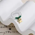 Elastic beaded ring with clear crystals, green beads and a golden butterfly charm - Hollow Butterfly Charm