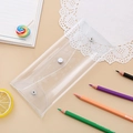 Flat lay of a transparent PVC stationery pouch with a silver snap button on a desk - Clear White
