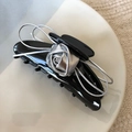 Detailed shot of black clip with silver metal rose and bow on a white plate - Silver Rose Claw Clip