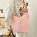 Pink quilted tote bag with floral handles and adjustable strap in lifestyle setting - Gourd Pattern Light Pink