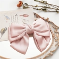 Détail d'une grande barrette à nœud en satin rose sur un miroir vintage au style rétro - Rose Clair