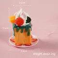 Miniature orange toy cake keychain with cream and fruit detail on pink background - Green Cream with Pink Phone Strap