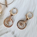 Polished gold alloy lobster clasp keychain set on soft white plush background - Metal Keychain Accessories