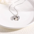 Silver heart pendant necklace with shimmering zircons on a white minimalist plate - Silver