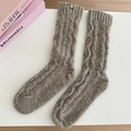Detail of cable knit wool socks in brown with a small leather brand patch on top - One Size / Oatmeal Khaki