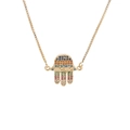 Detalle de colgante de mano de Hamsa dorado con circonitas de colores y grabado MAMA - Hamsa MAMA