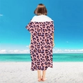 Pink microfiber hooded beach poncho with dark purple leopard print shown on a beach - Pullover Style - Leopard Print
