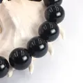 Strand of polished black agate round beads displayed on a white decorative shell - 14mm (Approx 27pcs)