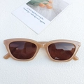 Gafas de sol ojo de gato color beige con lentes marrones sobre un fondo minimalista - Color Té con Leche