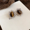 Macro view of oval tiger eye stud earrings with white pearl trim on brown knit fabric - 21# Brown Silver (Silver Pin)