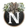 Detail of wooden welcome sign with letter N, black and white bow, and floral accents - Small / Letter N