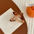 Detailed view of an amber butterfly hair claw clip with a glossy acetate texture on a card - Gradient Coffee