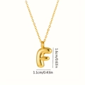 Dettaglio del ciondolo lettera F con dimensioni 1,6cm x 1,1cm su catena dorata - Lettera F