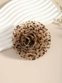 Vue détaillée de la broche fleur en mousseline à motif léopard sur fond beige élégant - Léopard Marron