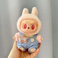 Labubu doll in pink rabbit ears and blue corduroy overalls with star bow accessory - Star-patterned Light Blue Overalls / First And Second Generation Keychains Are Compatible With La Cloth Dolls. Dolls Not Included.