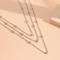 Primer plano de collar de tres capas en acero inoxidable plateado con cuentas - Collar de Plata