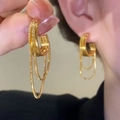 Detailed close-up of golden C-shaped layered metal chain fringe tassel earrings on ear - C-Shape Snake Chain / Gold