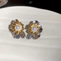 Macro detail of multi-layer flower earrings with pearls on a ceramic dish - Silver Pin Flower Pearl Style / Gold and Silver