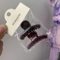 Close-up of two mini amber hair clips packed in a transparent bag with accessories tag - Small Hanger (Dark Coffee + Wine Red)