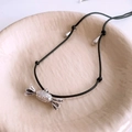 Detalle del colgante de metal con forma de caramelo y textura vintage en cordón negro - Collar-Plata-Negro