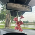 Close-up of handmade pink lily of the valley crochet plant hanging on a car rearview mirror - Gradient Pink Four Flowers