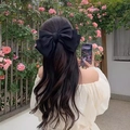 Elegant black oversized bow hair clip with ribbons worn on hair for women - Mysterious Black Bow Spring Clip (Satin)