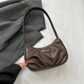 Bolso baguette plisado marrón oscuro con logo de moda sobre fondo de tela blanca - Marrón